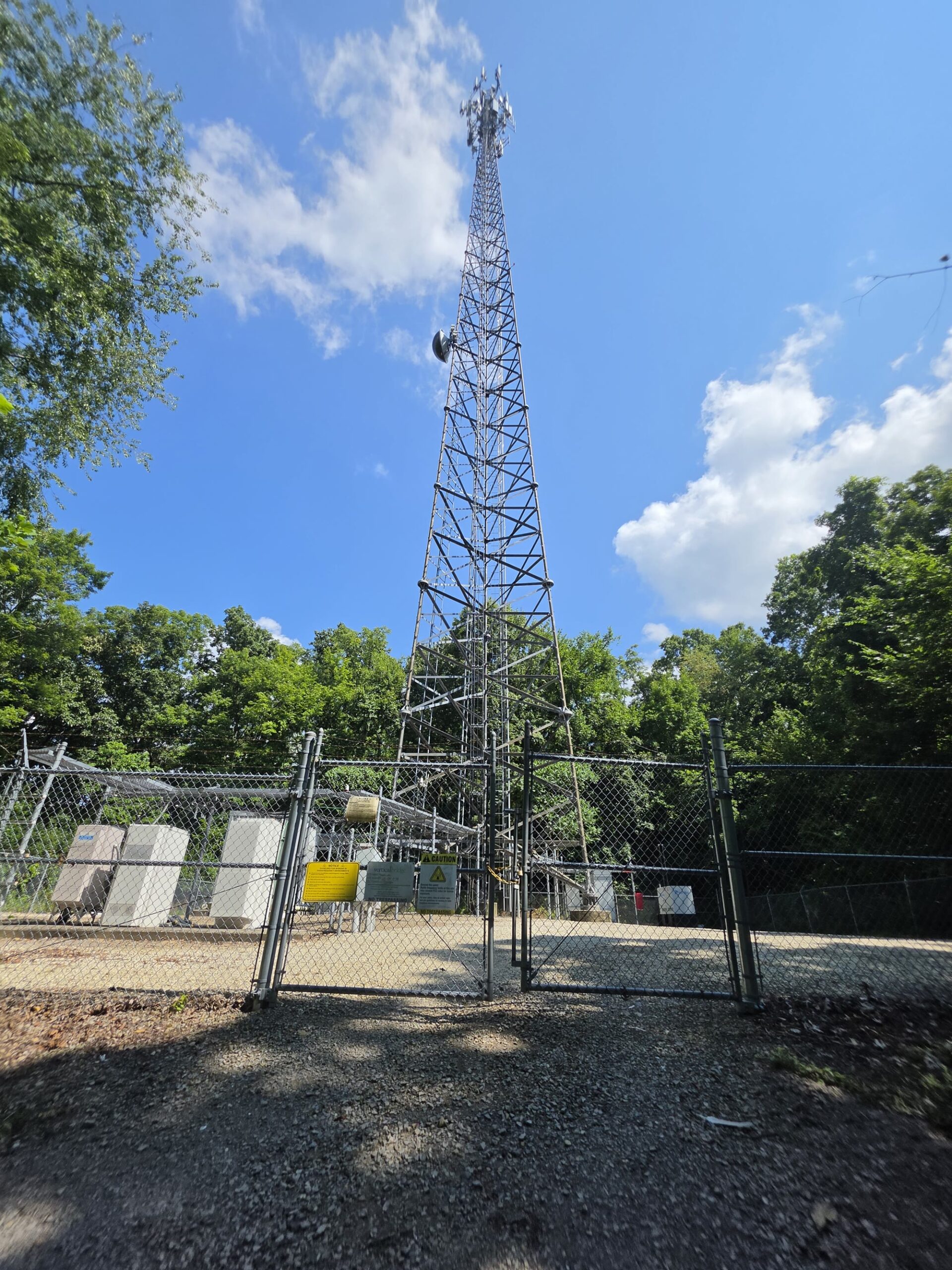 Lattice cell tower and ground equipment at a telecom inspection site